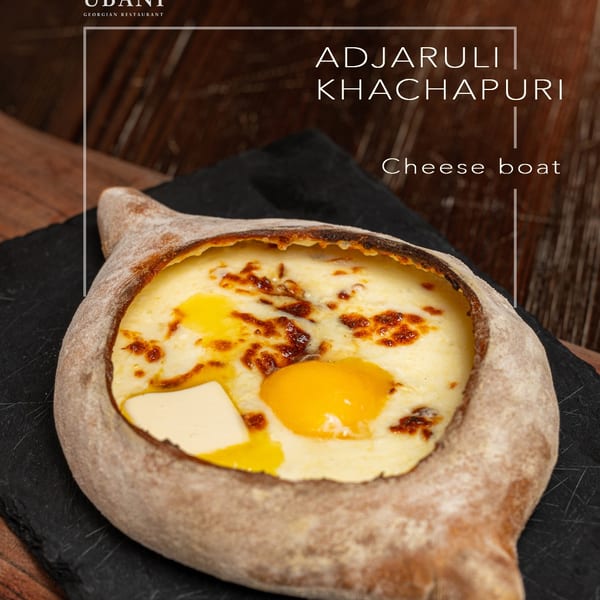 Adjarian Khachapuri, a boat-shaped bread filled with melted cheese, a raw egg yolk, and butter.